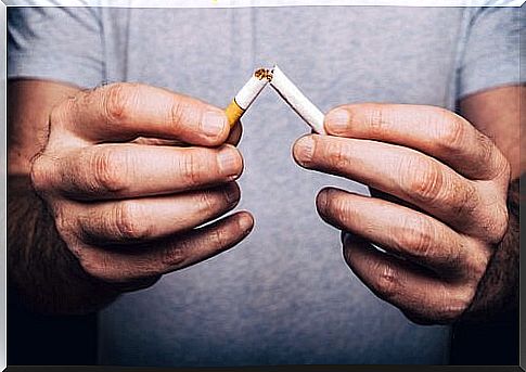 A person breaks a cigarette in half
