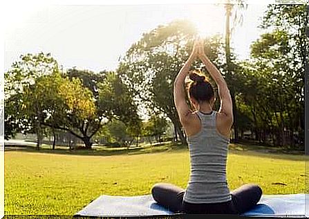 A woman doing yoga outdoors. 