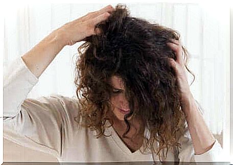 A woman scratching her hair.