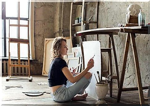 A woman painting a picture to break the monotony